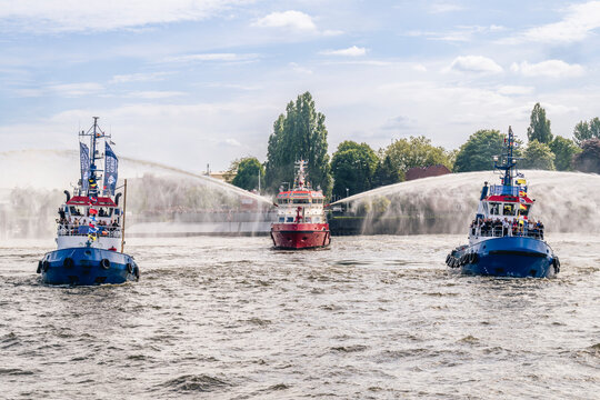 Fireboat and tugboats with water spray at Hamburg port anniversary