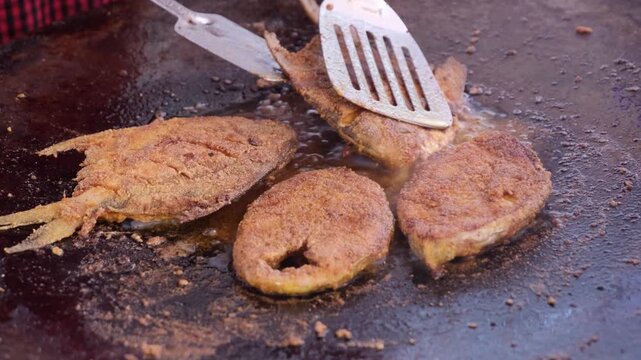 Fish fry on a frying pan with curry leaves. Close-up shot of Indian traditional Konkan style spicy fried fish. stock photo