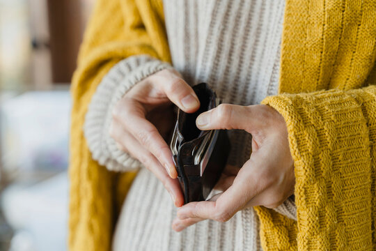 Close up of hands holding empty wallet showing financial stress