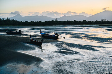 Traditional Longtail Boats at Low Tide During Sunset
