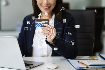 Businessman hand holding credit card and use laptop and smartphone in office.