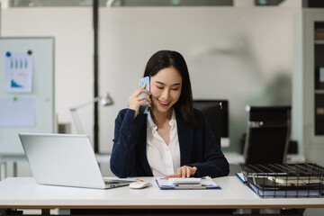 Business woman asian talking phones update plan working on laptop computers, online business.