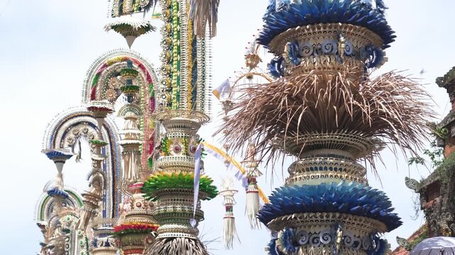 Colorful Balinese penjor decorations towering against blue sky