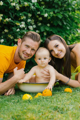 Family with Baby in Tub Outdoors with Oranges