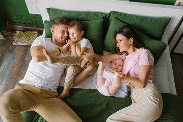 Family Relaxing Together In Green Bed Room
