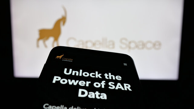 Stuttgart, Germany - 12-17-2025: Mobile phone with website of US satellite company Capella Space on screen in front of logo. Focus on top-left of phone display.