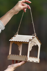 wooden bird feeder in human hands