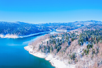 Obraz premium Winter panorama of Lokvarsko lake and Risnjak mountain in Gorski kotar in Croatia, snow on trees