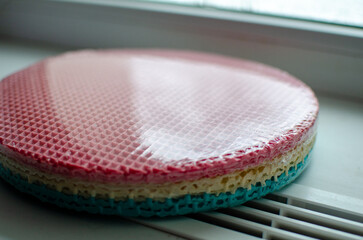 These are pre-packaged colorful waffle cake layers ready-made sponge sheets for assembling a layered cake, featuring a vibrant gradient of pink, beige, and turquoise, with a classic waffle texture, 