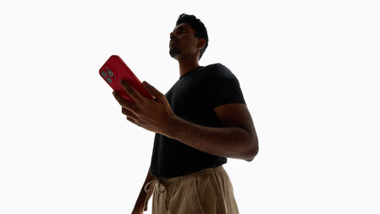 Man checking smartphone screen in studio. Concept of mobile app usage, daily digital habits, online services promotion, and technology lifestyle visuals.