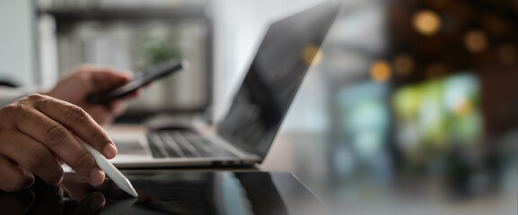 Business planning and strategy on digital workspace with hand using stylus on tablet, smartphone and laptop on desk, management productivity, modern office technology.