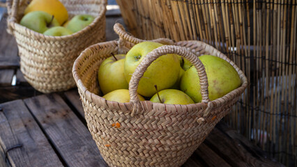 Two woven baskets filled with green apples.