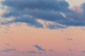 Beautiful soft pastel sunset sky with fluffy blue and pink clouds creating a serene and tranquil evening atmosphere at dusk.