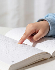 Close-up of a child&rsquo;s hands reading Braille in an open book, soft diffused lighting, textured pages, gentle tactile learning, emphasizing accessibility, early education, and discovery