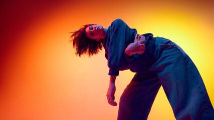 Woman posing with smartphone on gradient backdrop for social ads. Concept of youth-focused digital campaigns, trend-driven content creation, mobile-first marketing, and brand awareness promotion.