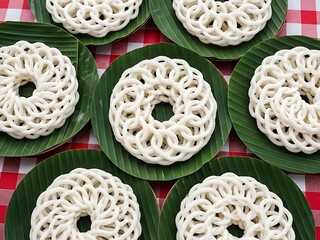 White lattice rice cakes on green banana leaves