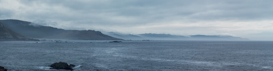 Overcast Coastal Landscape with Misty Mountains