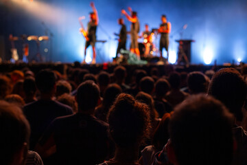 people watching music band playing on stage at concert, spectators crowd in music festival