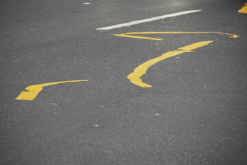 aged and misaligned yellow painted lines on a tarmac street 
