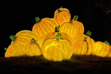 Christmas-themed pumpkin lanterns are placed on the lawn as part of the outdoor decorative lighting