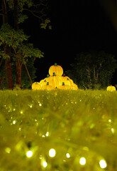 Christmas-themed pumpkin lanterns are placed on the lawn as part of the outdoor decorative lighting