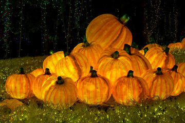 Christmas-themed pumpkin lanterns are placed on the lawn as part of the outdoor decorative lighting