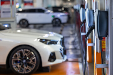 Obraz premium EV charging and electric car, Electric car charging station for charge EV battery, Plug for vehicle with electric engine, EV charger clean energy, Charging point at car parking lot