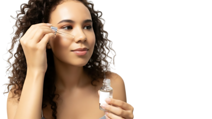Portrait of a woman with curly hair holding a small clear cosmetic bottle with a white label against a white background