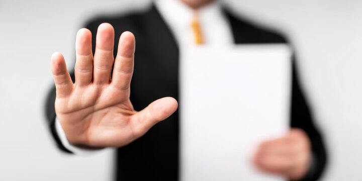 Businessman denying document with open palm gesture, showing refusal, rejection, and setting a boundary
