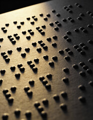 Macro shot of Braille text illuminated by soft glowing light on a dark minimal background, symbolizing tactile learning, accessibility, literacy, and inspirational education