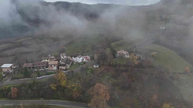 Fog rolling over forested hills in Castelletto Val Tolla, Emilia Romagna, Italy painting a mysterious and tranquil autumn winter scene with a thick blanket of haze, near Mignano dam lake