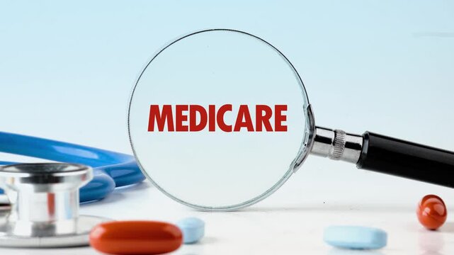 The term Medicare is revealed in red within a magnifying glass, sitting amongst pills and a stethoscope, representing the process of understanding healthcare options