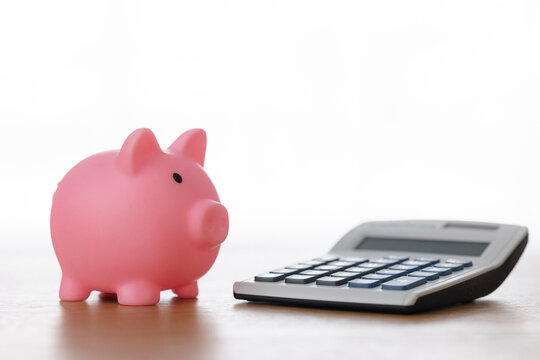 Piggy bank and calculator on white background. Business finance, savings and investment concept