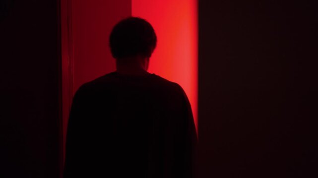 Emotional aftermath of a relationship argument as a man talks to himself in a doorway, gesturing angrily after a couple conflict at home