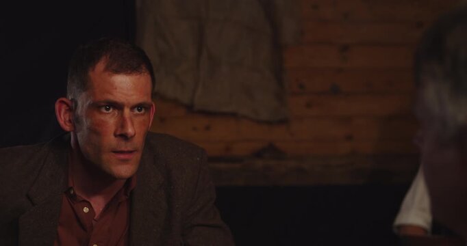 Prohibition era concept - An angry man violently interrogates another man in a gangster hideout