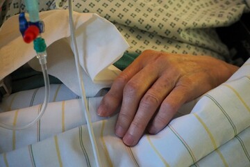 Alte kranke pflegebed&uuml;rftige Frau liegt mit Infusionskabeln in Krankenbett nach Operation im Krankenhaus