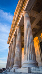 Naklejka premium Classical building facade with tall, fluted marble columns and detailed cornice.