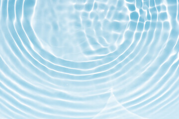 Blue water with ripples on the surface. Defocus blurred transparent blue colored clear calm water surface texture with splashes and bubbles. Water waves with shining pattern texture background.