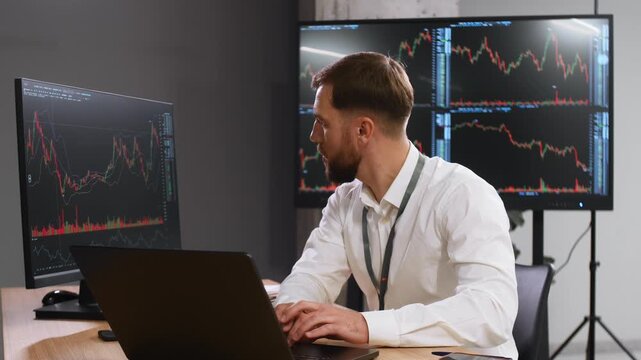 The document is in notepad. Handsome businessman is in the office with stock exchange market information on displays.