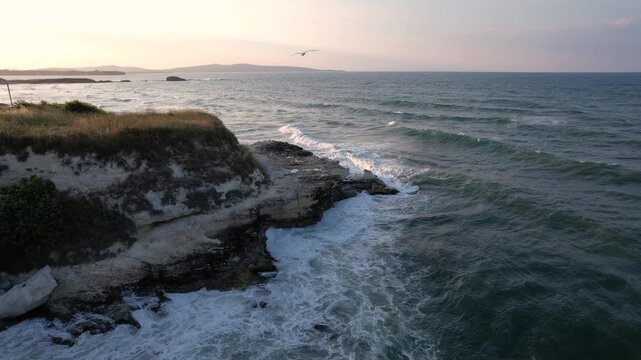 Aerial view of the rugged coastline where the cliff's edge meets the powerful ocean waves creating a dynamic contrast of textures, Lozenets, Tsarevo, Bulgaria.