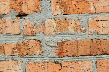 Fragment of a brick wall with cracks.Destruction of bricks under the influence of cold and frosty weather.