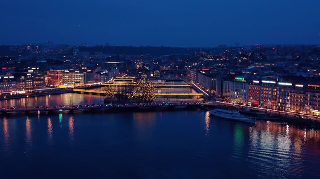 Aerial view of the illuminated Pont du Mont-Blanc reflecting off the dark waters, contrasting with the city lights, Geneve, Geneve, Switzerland.