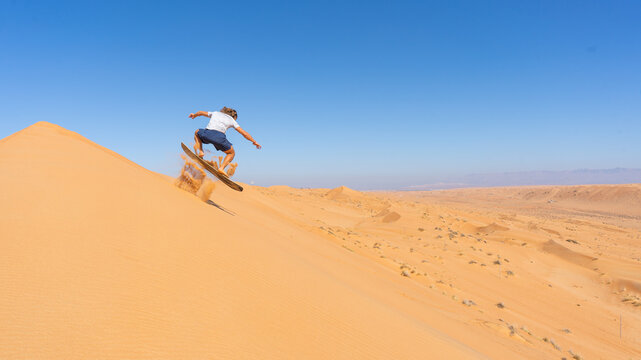 Sandboarding on desert dunes, extreme adventure sport