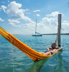 Man relaxing in water hammock enjoying tropical vacation in bacalar,mexico