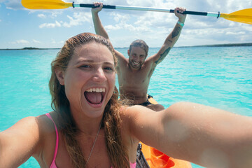 Happy couple taking selfie enjoying summer kayaking vacation in bacalar,mexico