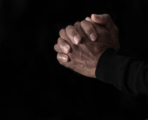 praying to god with hands showing his religious faith with God  Caribbean man praying with black background with people stock photo stock image