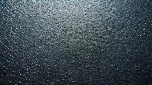 Dark Textured Surface with Subtle Highlights and Shadows Abstract Background Keywords: dark, texture, surface, background, abstract, grunge, rough, stone, slate, rock, material, pattern, detail
