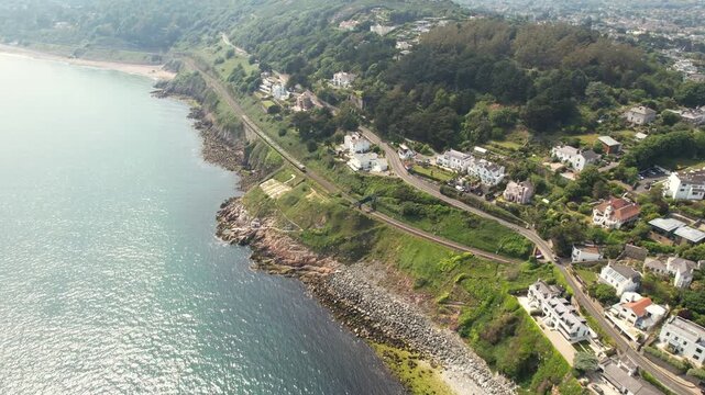 Aerial view of the coastal railway line, contrasting with the blue sea and green landscape, creating a stunning visual, Dalkey, County Dublin, Ireland.