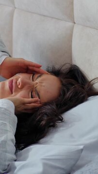 Unhealthy Caucasian woman waking up lying in bed holding head upset with headache pain symptom health difficulty female girl awaking migraine tension fever in bedroom home insomnia exhaustion tired