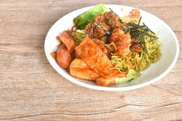 Korean vegetable noodles topping tokpokki slice pork sausage and cabbage with tofu dressing spicy sauce couple fried chicken topping dry seaweed on plate
